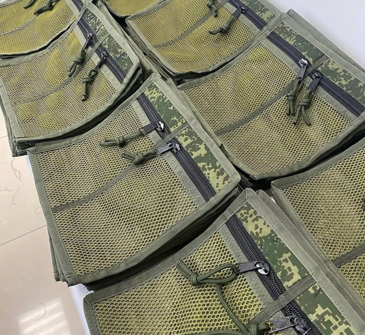 Партия готовых изделий IRON TACTICA в камуфляжной расцветке разложена на столе